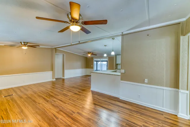 a view of empty room with wooden floor