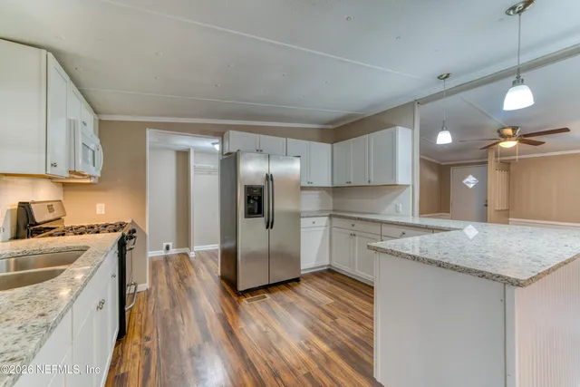 a kitchen with a center island wooden floor stainless steel appliances and cabinets