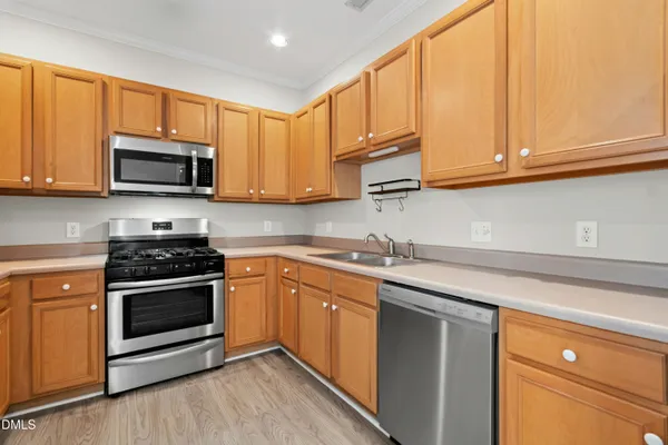 a kitchen with stainless steel appliances granite countertop a sink a stove and microwave