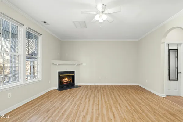 wooden floor fireplace and windows in an empty room