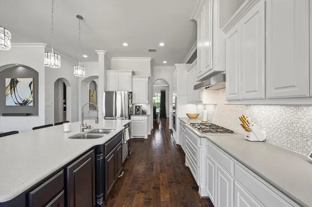 a kitchen with kitchen island stainless steel appliances sink stove and cabinets