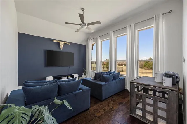 a living room with furniture a ceiling fan and a flat screen tv