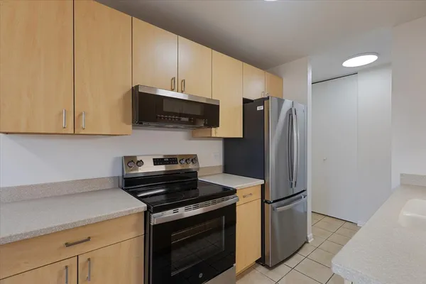 a kitchen with stainless steel appliances white cabinets and a stove top oven
