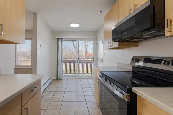 a kitchen that has a sink a stove and cabinets