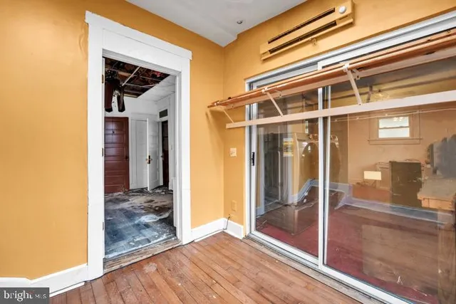 a view of a room that has a large window and wooden floor