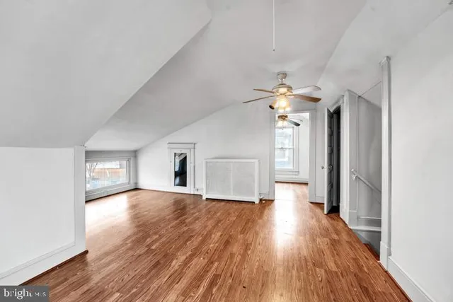 a view of a hallway with wooden floor and a chandelier