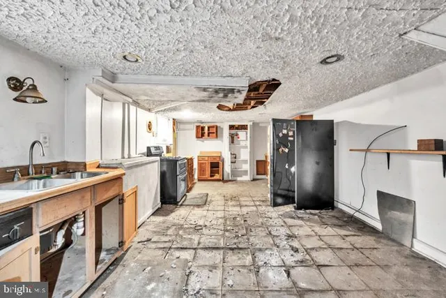 a large kitchen with stainless steel appliances granite countertop a refrigerator and a stove