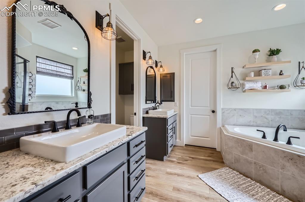 8735 Palomino Rdg View Peyton, CO 80831 - Photo 17 of 48 a bathroom with a tub sink and mirror