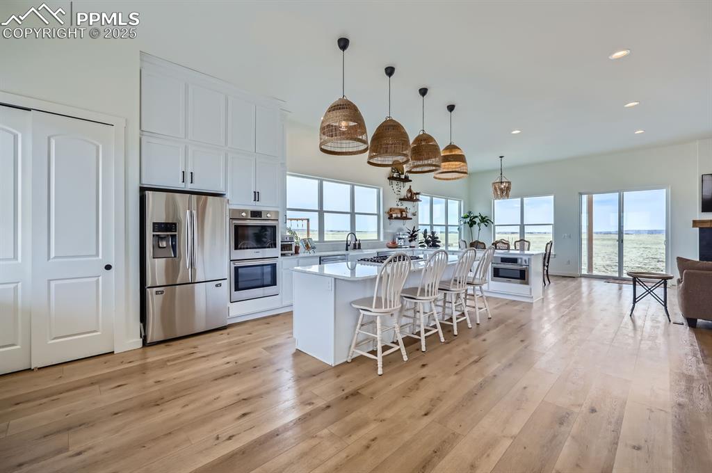 8735 Palomino Rdg View Peyton, CO 80831 - Photo 28 of 48 a kitchen with stainless steel appliances a dining table chairs stove and refrigerator