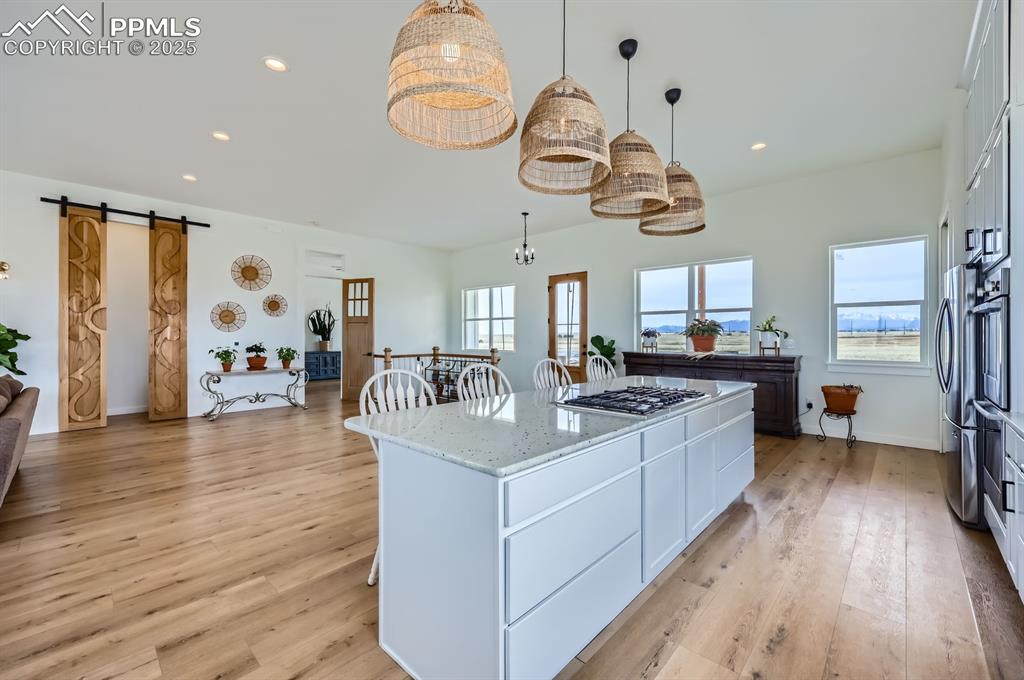 8735 Palomino Rdg View Peyton, CO 80831 - Photo 30 of 48 a kitchen with stainless steel appliances granite countertop a stove and wooden floor