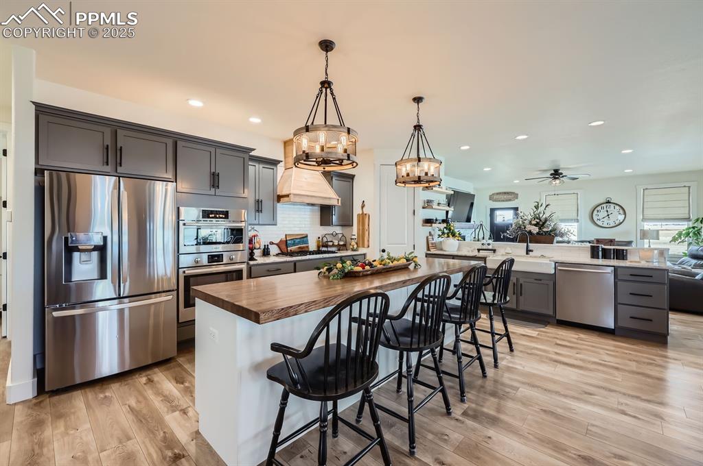 8735 Palomino Rdg View Peyton, CO 80831 - Photo 9 of 48 a kitchen with stainless steel appliances granite countertop a table chairs stove and refrigerator