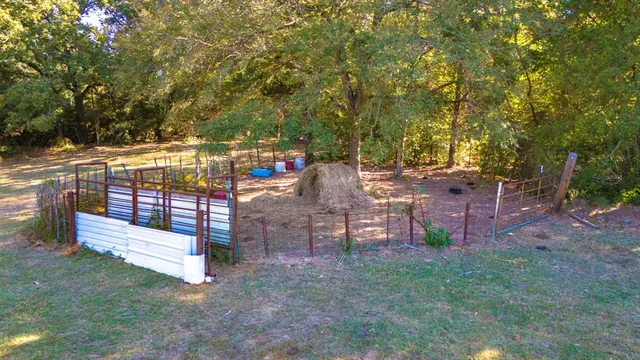 a view of yard with swimming pool and trees in the background