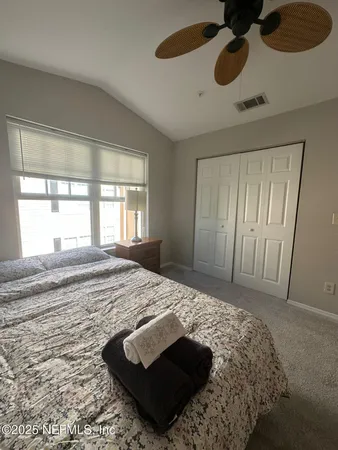 a bedroom with a bed and a dresser next to a window