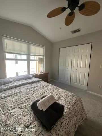 a bedroom with a bed and a dresser next to a window