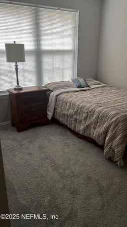 a bedroom with a bed a lamp and a window