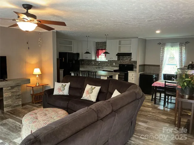 a living room with furniture kitchen view and a fireplace