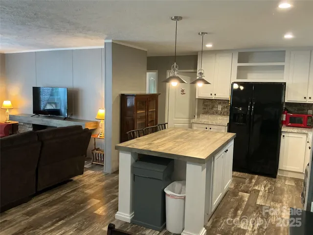 a kitchen with a refrigerator a sink and wooden floor