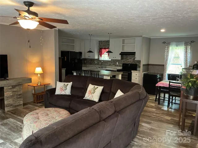 a living room with furniture kitchen view and a fireplace