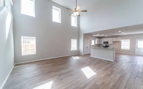 a view of kitchen with granite countertop stainless steel appliances refrigerator wooden floor and cabinets