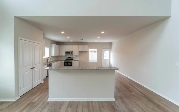 a view of kitchen with stainless steel appliances granite countertop refrigerator sink and stove