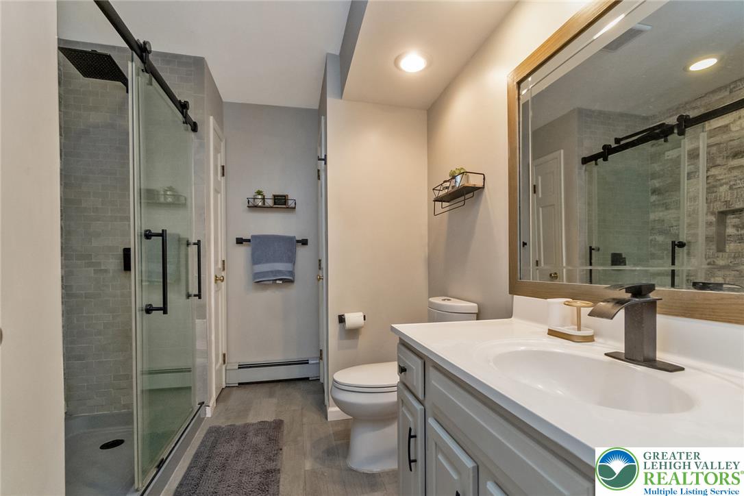 9461 Red Road Kempton, PA 19529 - Photo 34 of 55 A contemporary hall bathroom with a glass-enclosed shower and modern fixtures offers a serene, functional space.