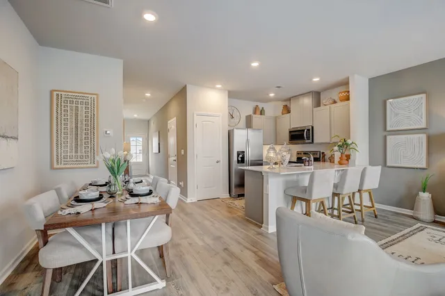 a living room with kitchen island furniture and a dining table with kitchen view