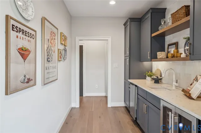 a view of a hallway to a room with wooden floor cabinet and windows