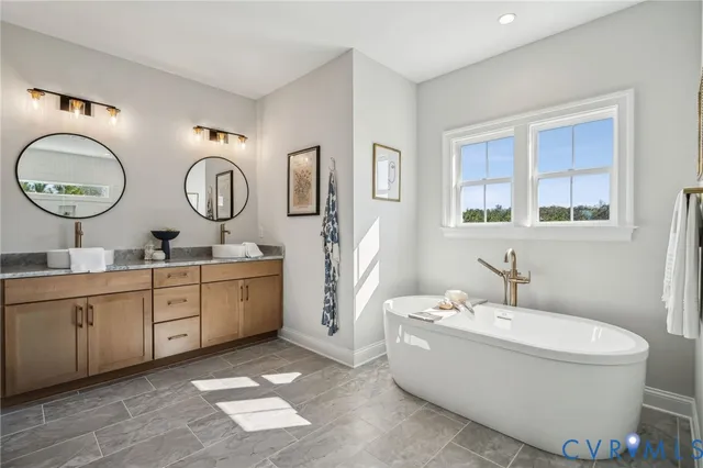 a bathroom with a double vanity sink a mirror and a bathtub