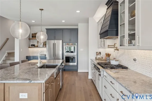 a kitchen with granite countertop a sink a counter space appliances and cabinets