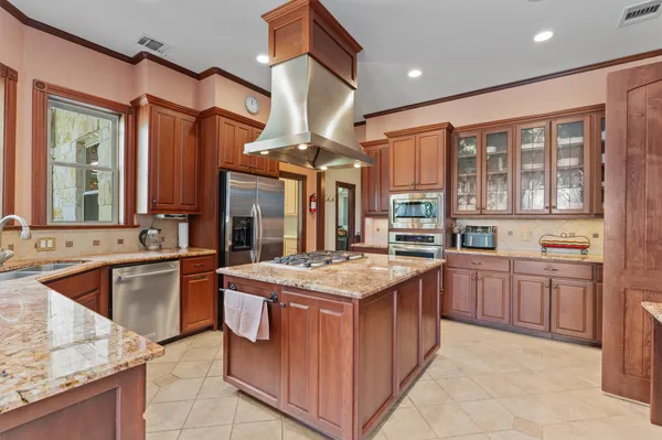 a kitchen with stainless steel appliances granite countertop a stove a sink and a refrigerator