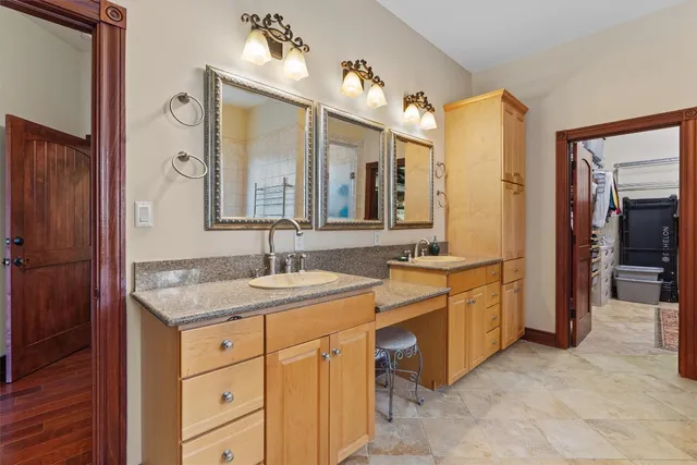 a spacious bathroom with a granite countertop sink and a mirror