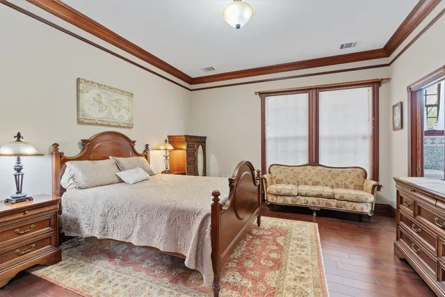 a bedroom with a bed couch and a large window