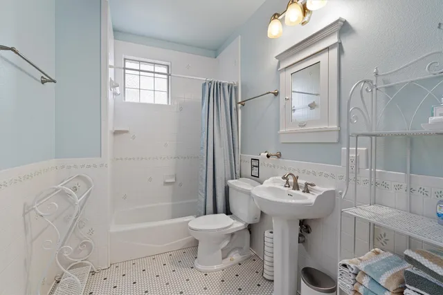 a bathroom with a sink toilet tub and shower