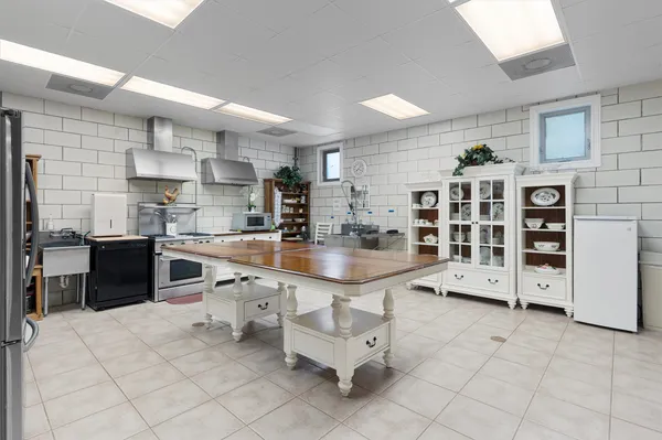 a large white kitchen with a large window and cabinets