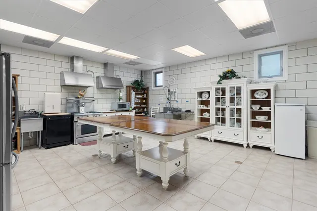 a large white kitchen with a large window and cabinets