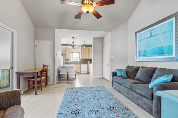 a living room with furniture a chandelier and a dining table