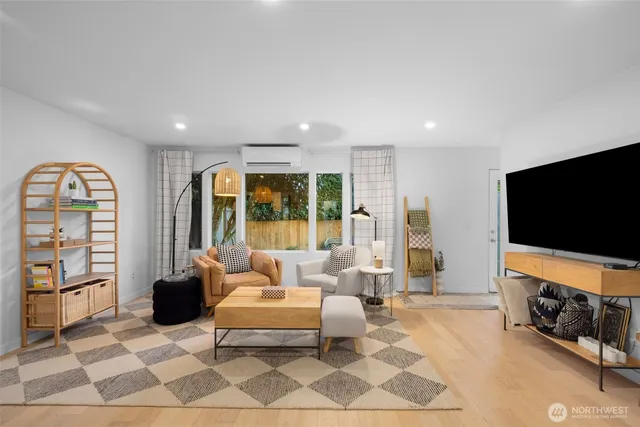 a living room with furniture a flat screen tv and a floor to ceiling window