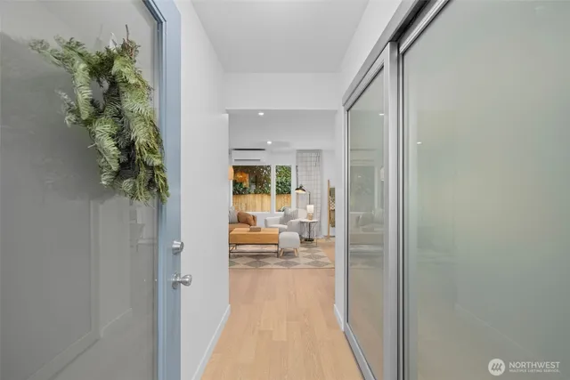 a view of a hallway with wooden floor and a living room