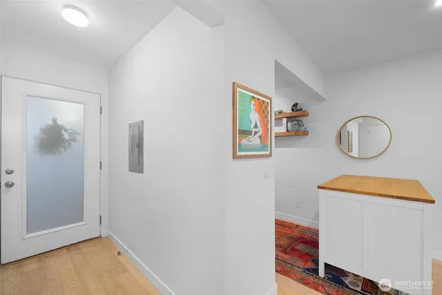 an empty room with wooden floor and mirror