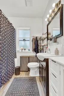 a bathroom with a sink toilet a mirror and shower