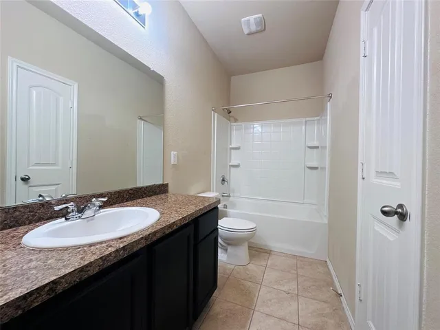 a bathroom with a granite countertop sink a toilet and shower