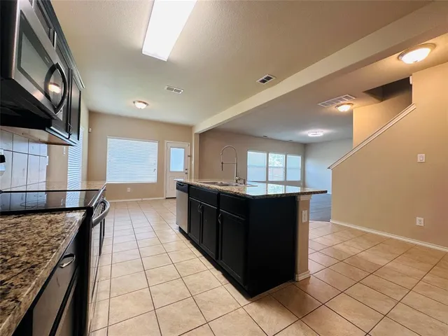 a kitchen with granite countertop lots of wooden cabinets