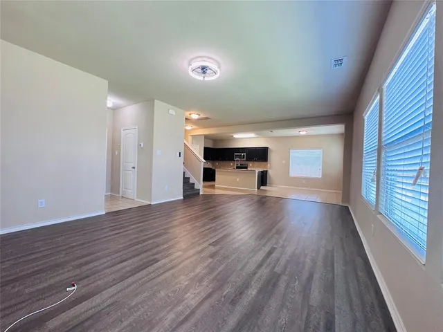 a view of empty room with a windows and wooden floor