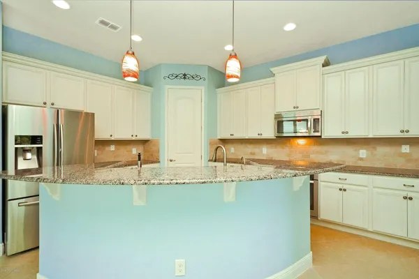 a kitchen with stainless steel appliances granite countertop a sink a stove top oven a counter space and cabinets
