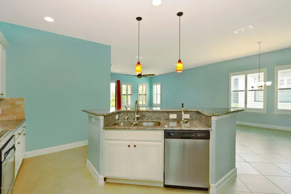 a kitchen with stainless steel appliances granite countertop a sink a window and a counter top space