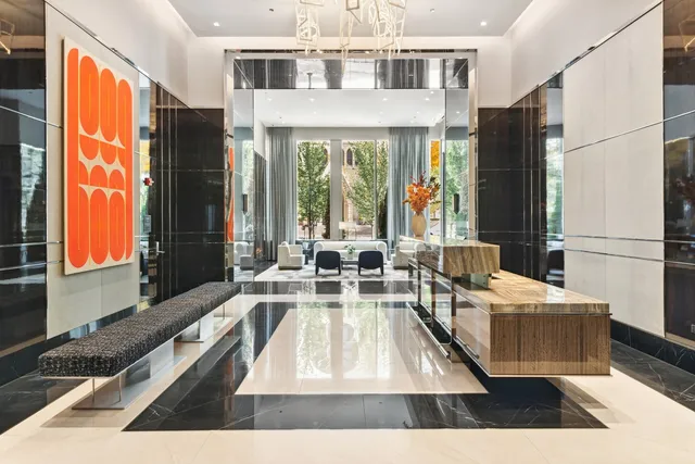 a living room with stainless steel appliances furniture wooden floor and a large window