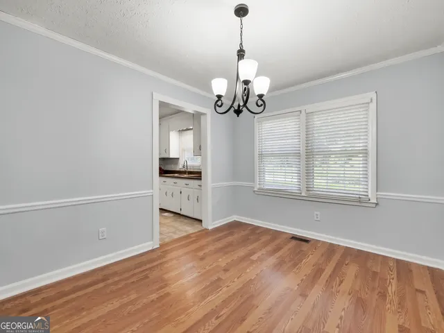a view of a kitchen with wooden floor and a ceiling fan
