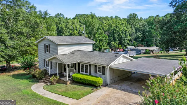 an aerial view of a house with garden space and a trees all around
