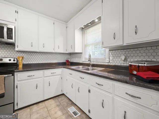 a kitchen with granite countertop white cabinets sink and dishwasher