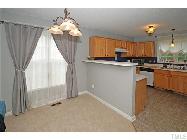 4712 Valley Stream Drive Raleigh, NC 27616 - Photo 25 of 25 a kitchen with kitchen island granite countertop a stove a sink a refrigerator and a dining table
